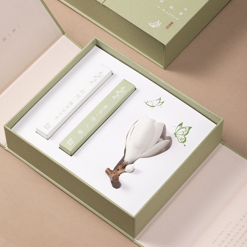 Open sage green floral gift box showing the two incense packs and magnolia holder