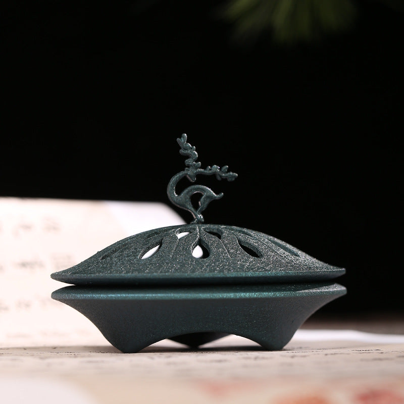Blue-green deer lid burner in a styled setting