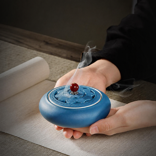 Blue ceramic lotus incense burner held in two hands