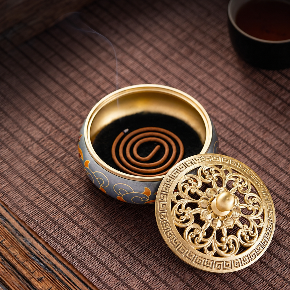 Open brass incense burner with a coil and the lid placed beside it